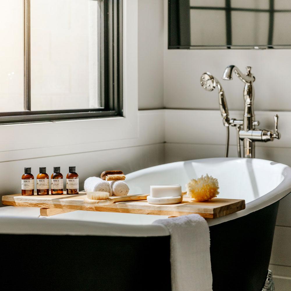 Le Labo Rose 31 travel size bottles and other products on bath tub