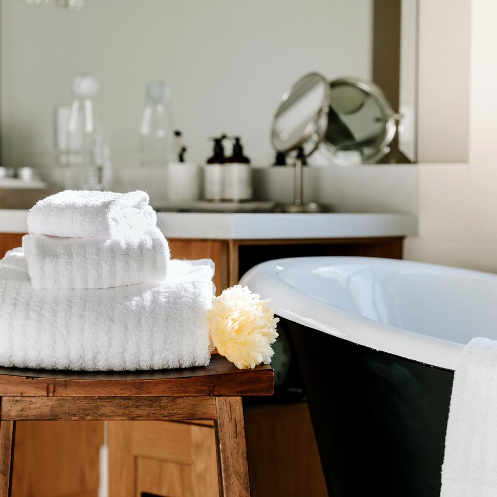Fairmont towels collection on a stool by the tub